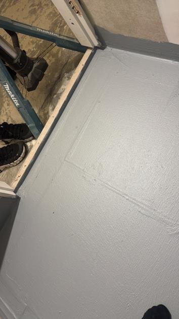 Uneven membrane at hob-to-wall junction — thin spot identified — second coat required before tiling.