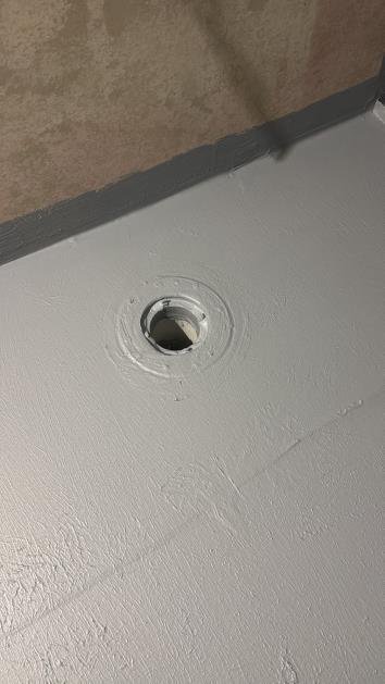 No cove fillet at floor-to-wall internal angle — moisture breach risk — cove and re-membrane required.